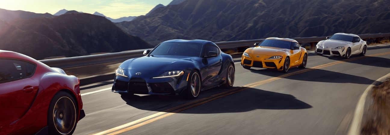 several 2020 toyota supra's driving down a mountain